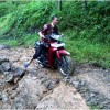 Salah seorang pengendara saat melintasi jalan yang berbatu.